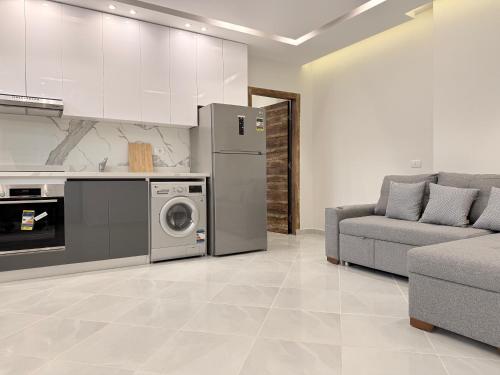 a kitchen with a refrigerator and a couch and a stove at Bohemia palace in Hurghada
