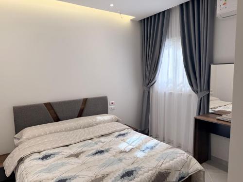 a bedroom with a bed and a window with curtains at Bohemia palace in Hurghada