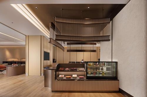 a restaurant with a food counter in a room at Hilton Garden Inn Harbin Haxi in Harbin