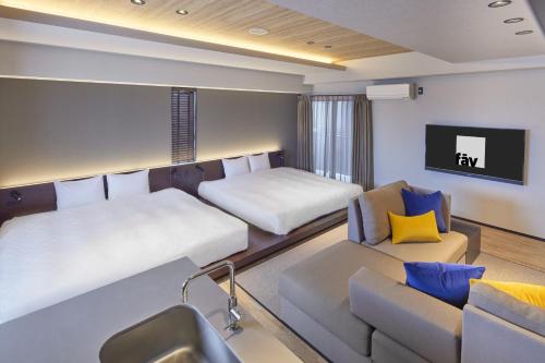 a hotel room with two beds and a couch at fav TAKAMATSU in Takamatsu
