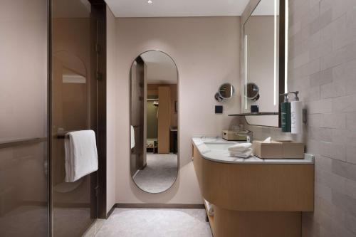 a bathroom with a sink and a mirror at Hilton Garden Inn Harbin Haxi in Harbin