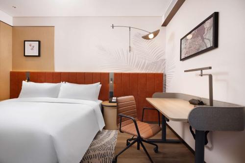 a hotel room with a bed and a desk at Hilton Garden Inn Harbin Haxi in Harbin