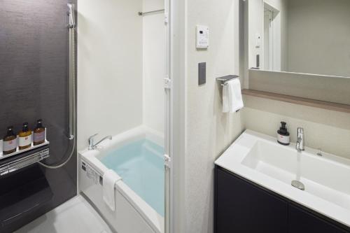 a bathroom with a sink and a bath tub at fav TAKAMATSU in Takamatsu