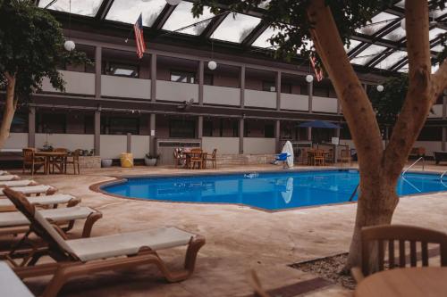 a pool with chairs and tables and a building at Americinn by Wyndham Appleton Downtown in Appleton