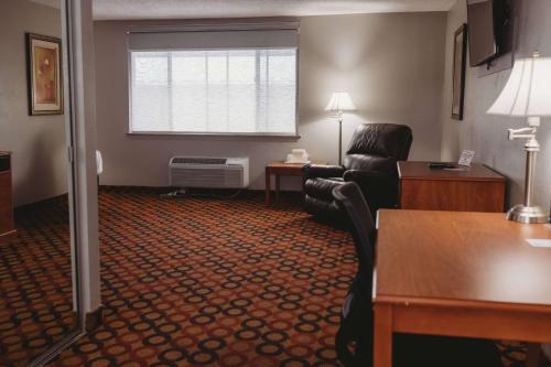 a living room with a couch and a chair in a hotel room at Americinn by Wyndham Appleton Downtown in Appleton
