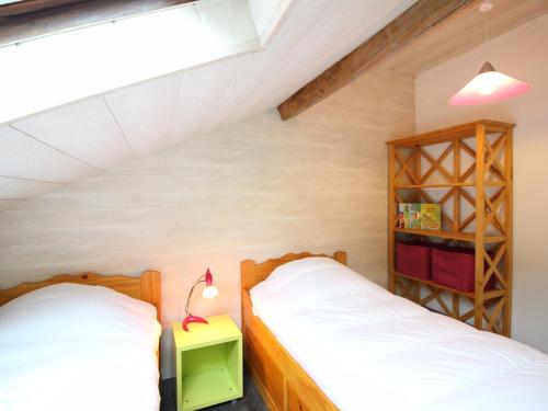 une chambre avec deux lits et une étagère dans l'établissement Appartement F3 Mont-Dore à 200m des thermes, parking sécurisé, 4 couchages, sans ascenseur - FR-1-415-61, à Le Mont-Dore