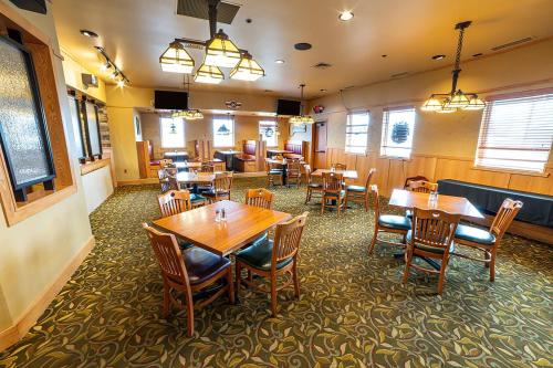 a dining room with wooden tables and chairs at The Lodge at Brainerd Lakes, Trademark Collection by Wyndham in Baxter