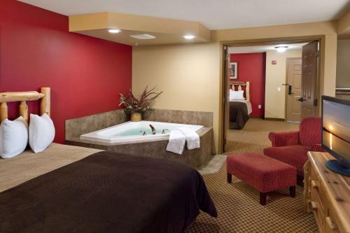 a hotel room with a bed and a bath tub at The Lodge at Brainerd Lakes, Trademark Collection by Wyndham in Baxter