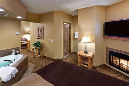 a hotel room with a tub and a fireplace at The Lodge at Brainerd Lakes, Trademark Collection by Wyndham in Baxter