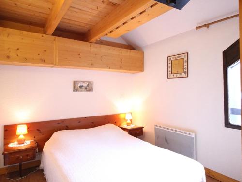 - une chambre avec un lit blanc et 2 tables de chevet dans l'établissement Appartement au pied des pistes avec 2 chambres et local à skis - FR-1-415-113, à Le Mont-Dore