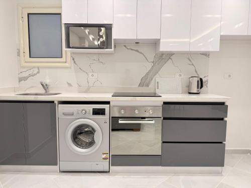 a kitchen with a washing machine and a sink at Bohemia palace in Hurghada