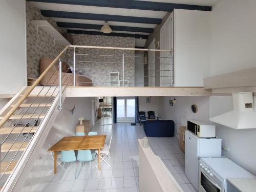 Ce loft comprend une table en bois et une salle à manger. dans l'établissement Maison lumière près plage avec terrasse, 2 chambres, BBQ, parking, linge fourni - FR-1-778-20, à Saint-Georges-dʼOléron