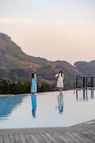 two young girls standing on the edge of a swimming pool at XMAN Sunrise Peaks Resort--Free Pick-up in Zhangjiajie