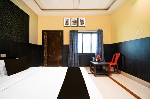 a bedroom with a bed and a table and a chair at Hotel O Jannat in Chupra