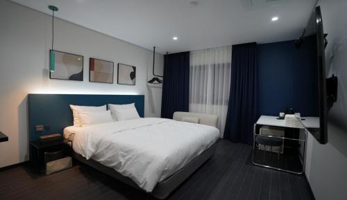 a bedroom with a large bed and a desk at 호텔그랑파리 in Gwangju