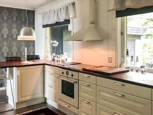 a kitchen with white cabinets and a stove top oven at 7 person holiday home in Molde in Molde