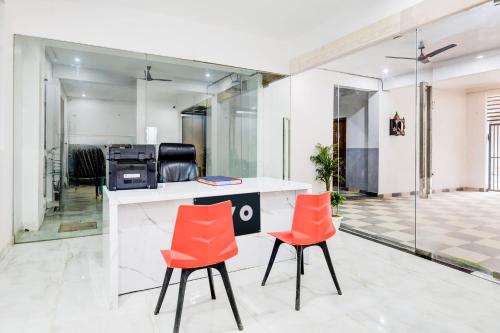 an office with orange chairs and a counter at Super Hotel O Divine Stay in Gurgaon
