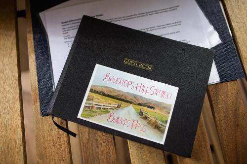 a black book with two cards on top of a table at Mackenzie Pass Retreat by Tiny Away in Burkes Pass