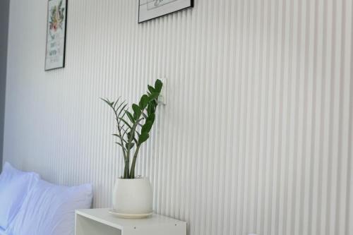 a plant in a white vase on a table in a bedroom at The Twin Hanger Cabin A in Hermosa