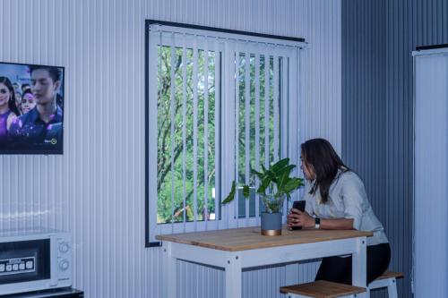 a woman sitting at a table in front of a window at The Twin Hanger Cabin A in Hermosa