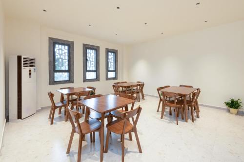 a dining room with wooden tables and chairs at Yangshuo Hidden Dragon Villa in Yangshuo