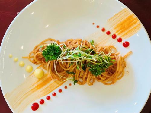 a plate of pasta on a white plate at SANDALS AQUILA HOTEL in Bao Loc