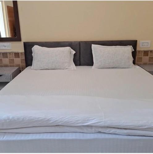 a large white bed with two pillows on it at Prantik Retreat in Bāgnān