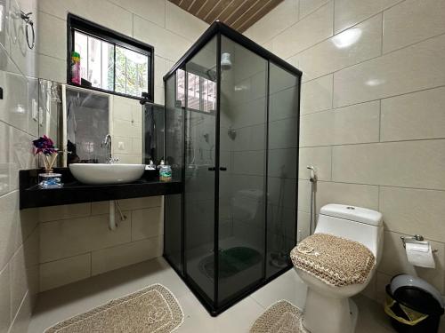a bathroom with a shower and a toilet and a sink at Enseada dos corais - Cabo de Santo Agostinho com piscina grande in Cabo de Santo Agostinho