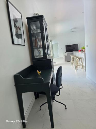 a black desk with a chair and a mirror at Bougain Villas in Salad Beach