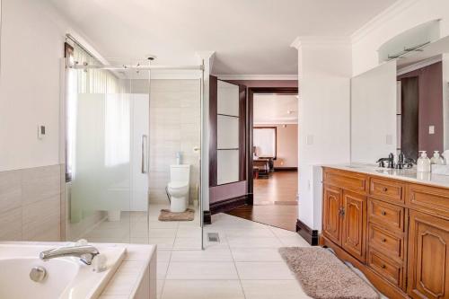 a bathroom with a tub and a sink and a toilet at Waterfront Mansion with River & Mountain View, 40 Minutes from Montreal in Beloeil Village