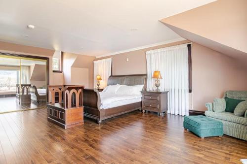 a bedroom with a bed and a couch and a chair at Waterfront Mansion with River & Mountain View, 40 Minutes from Montreal in Beloeil Village