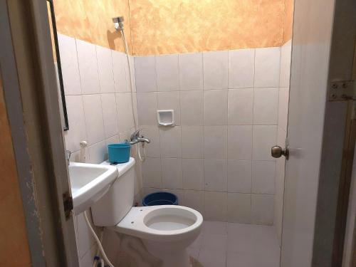 a small bathroom with a toilet and a sink at MCT Hotel in Manila