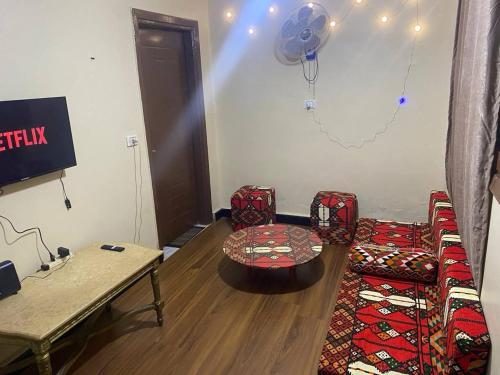 ein Wohnzimmer mit Stühlen, einem Tisch und einem Tisch in der Unterkunft Downtown Cairo Urban Retreat in Kairo