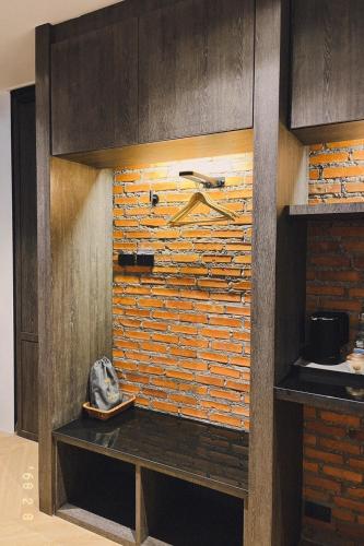 a kitchen with a brick wall and a shelf at Santisookmidtown Pattani in Kampong Rusamileh
