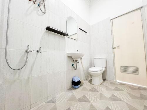 a white bathroom with a shower and a toilet at Griya Rejodani Homestay Jogja in Ngaglik