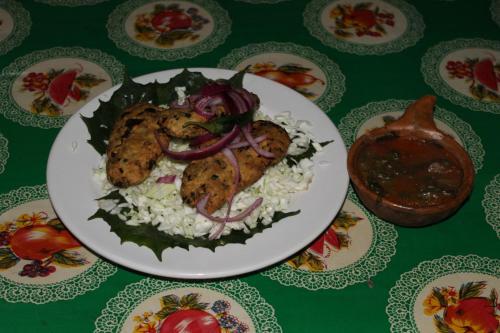 a plate of food with chicken and rice on a table at Campamento Yaax Che en Calakmul in Conhuas