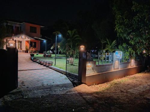a fence in front of a house at night at 7TH HEAVEN Kannur in Chakkarakkal