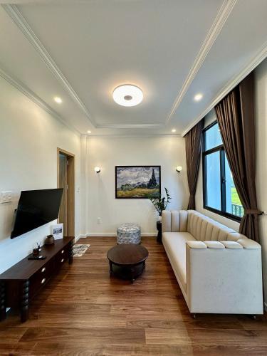 a living room with a white couch and a table at CONIHOUSE - Homestay & Villa in Thôn Lại Thê