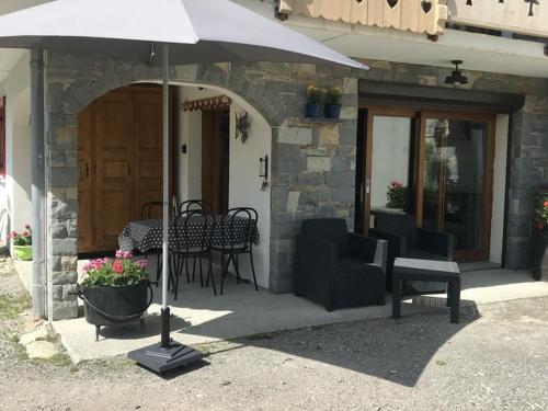 a patio with an umbrella and chairs and tables at Chalet Douillet à Châtel - 5 Pers., 3 Ch. - FR-1-676-212 in Châtel