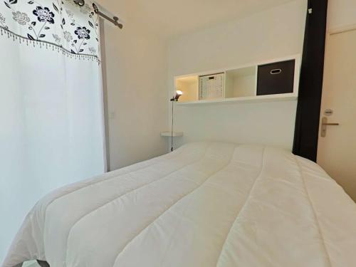 un lit blanc dans une chambre avec une fenêtre dans l'établissement Charmant 2 pièces vue mer à Saint Gilles Croix de Vie - FR-1-224-817, à Saint-Gilles-Croix-de-Vie