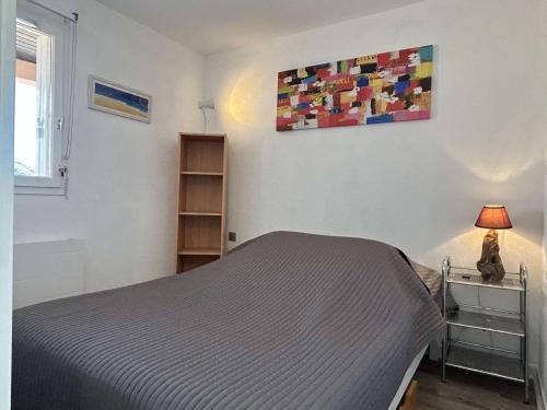 - une chambre avec un lit et un chat assis sur une table dans l'établissement Appartement 2 pièces à Banyuls-sur-Mer avec Parking Privé - FR-1-225C-160, à Banyuls-sur-Mer