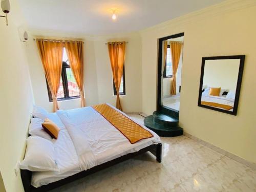 a bedroom with a large bed and a mirror at White Legacy Ooty - Families Only in Ooty
