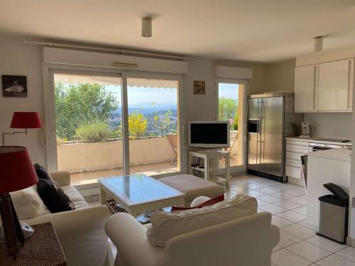 Il comprend un salon avec des canapés blancs et une cuisine. dans l'établissement Appartement 2 pièces avec terrasse et piscine - 4 pers - Cannes - FR-1-609-111, à Cannes
