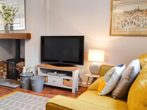 a living room with a tv and a couch at The Horseshoes in Hornsea