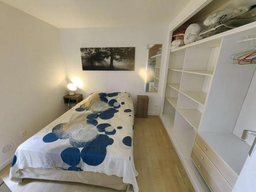 - une chambre avec un lit dans une pièce dotée d'étagères dans l'établissement Joli T2 rez-de-jardin avec piscine et parking - FR-1-607-211, au Cap d'Agde