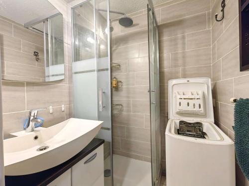 une salle de bain avec un lavabo et une douche dans l'établissement Joli T2 rez-de-jardin avec piscine et parking - FR-1-607-211, au Cap d'Agde