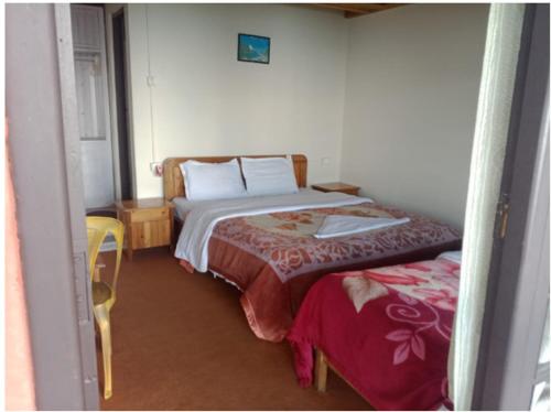 a small bedroom with a bed and a chair at Yankee Village Retreat Reshop in Lava