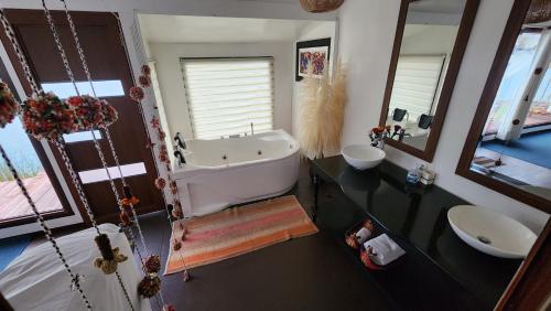 a bathroom with a tub and two sinks and a mirror at Titicaca island lodge peru in Puno