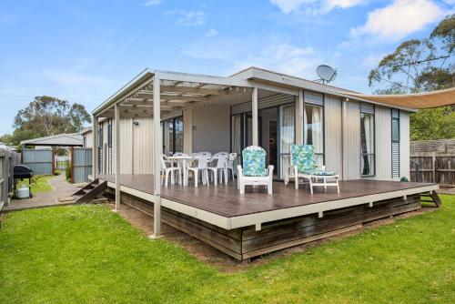 una casa con terraza y sillas. en Outlook Escape by Ready Set Stay - BYO LINEN & TOWELS, en Cowes