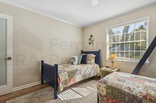 a bedroom with two beds and a window at 4937 Windward Place home in Fernandina Beach